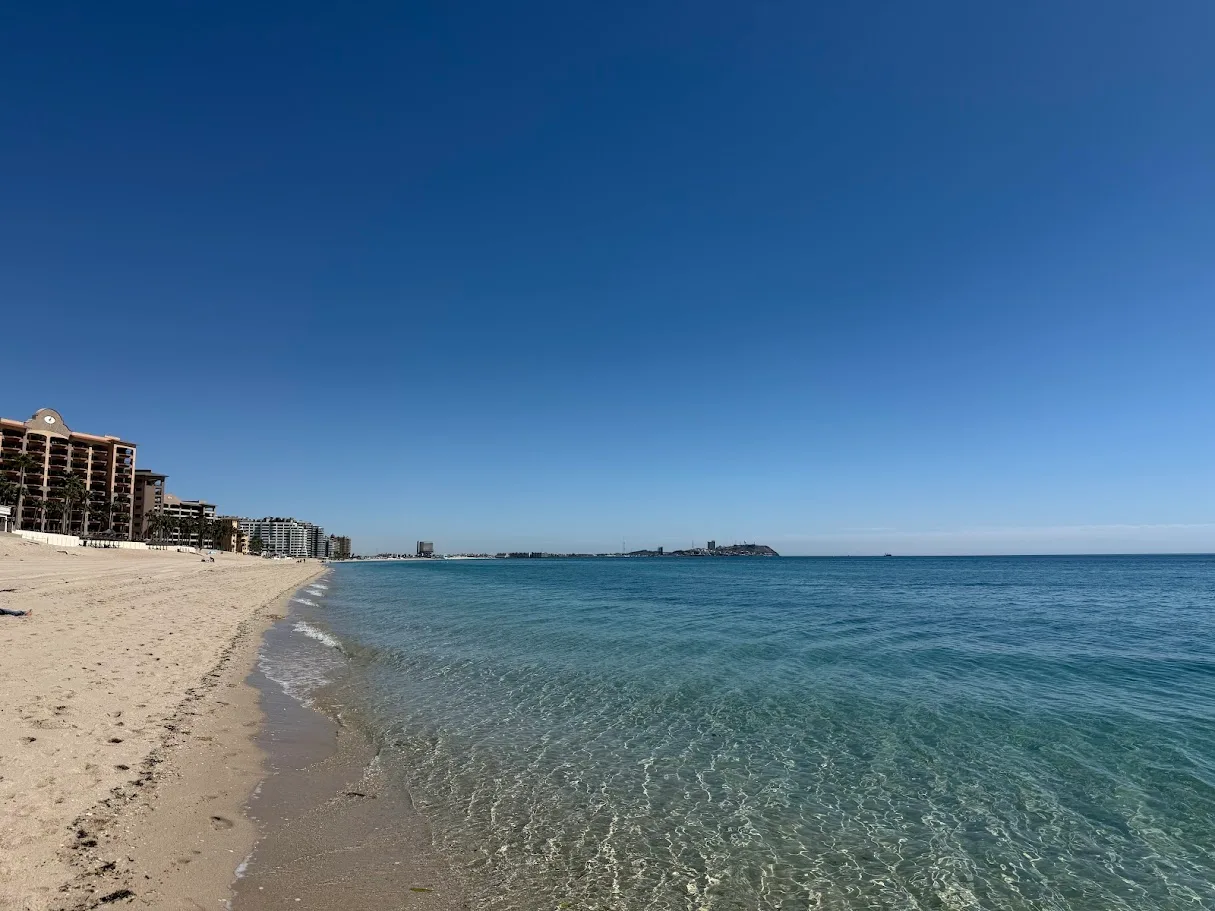 A quiet stretch of beach in Rocky Point, Mexico, with resort towers along the shore